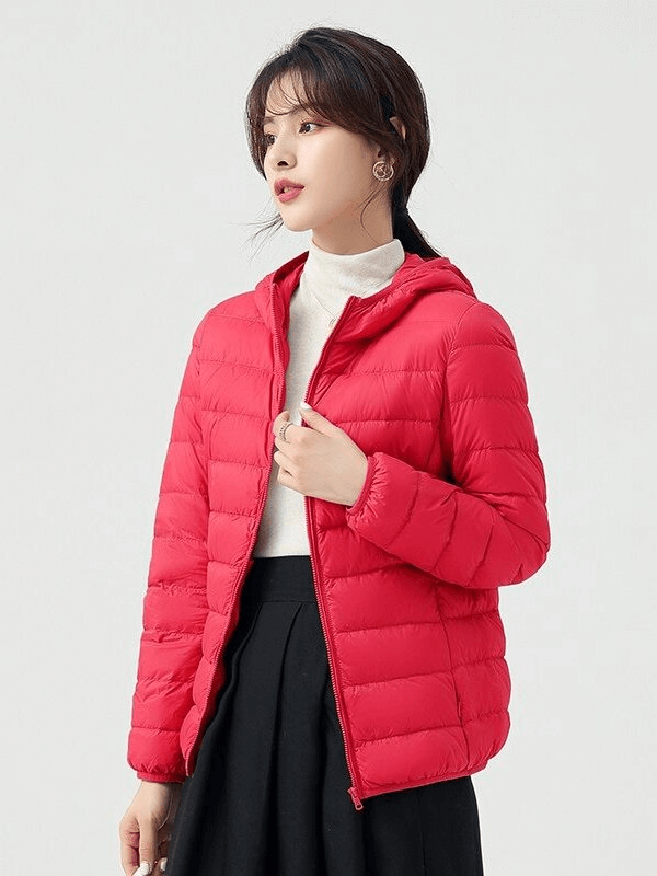 Woman wearing stylish red down jacket with hood, highlighting lightweight nylon design and 90% down insulation for warmth.